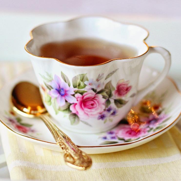 a tea cup on a saucer with a tea spoon